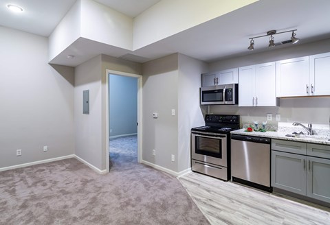 A kitchen with a microwave, oven, and stove top.