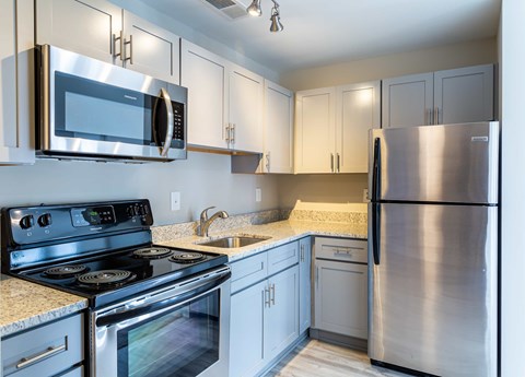 A kitchen with a stove, microwave, and refrigerator.