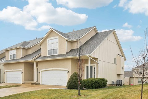 A large, two-story house with a garage on the left side.