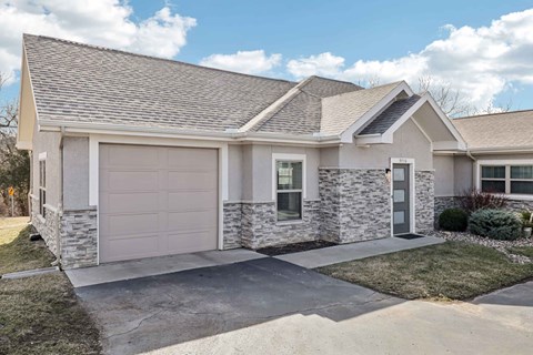 A two-car garage with a stone facade and a grey roof.