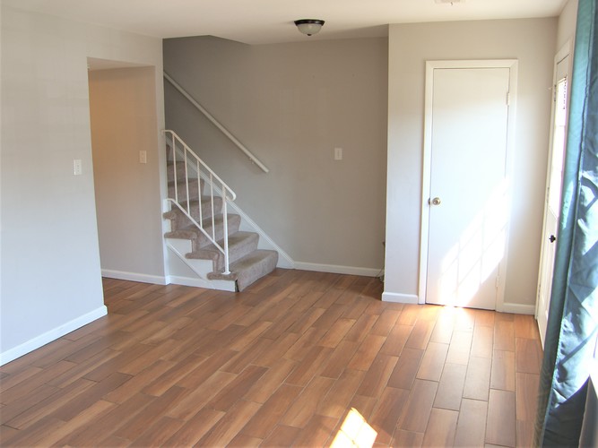 A room with wooden floors and a staircase.