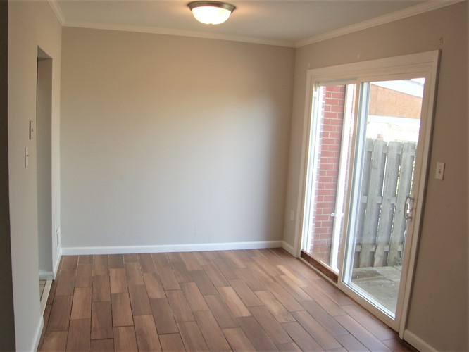 A room with wooden flooring and a sliding glass door.