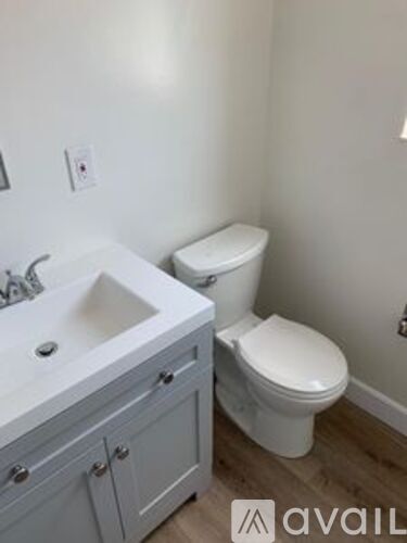 A white toilet sits next to a sink in a bathroom.