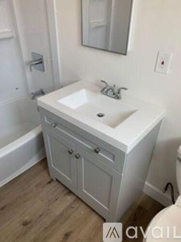 A white bathroom sink with a cabinet below it.