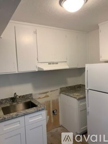 A kitchen with white cabinets and a granite countertop.