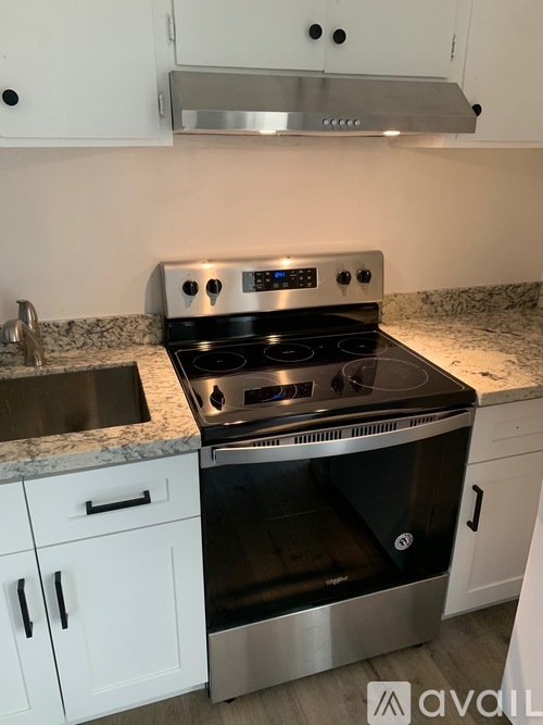A modern kitchen with a stove top oven and a sink.