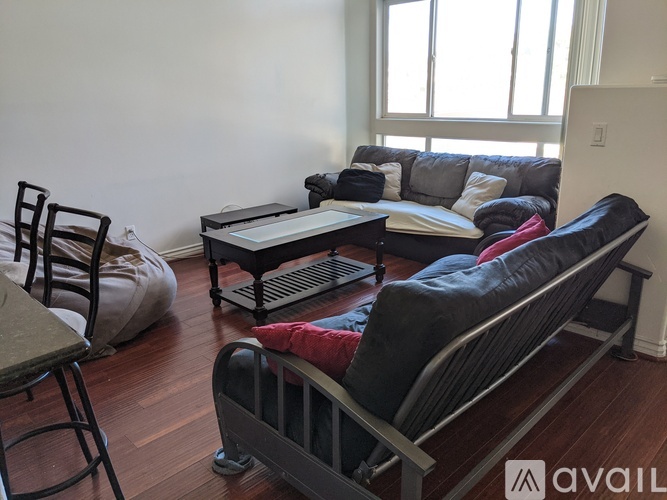 A living room with a black couch and a black chair.