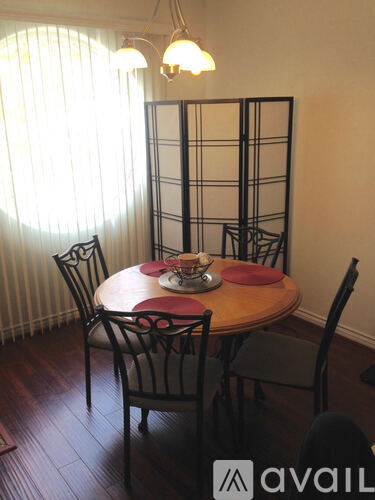A dining room with a round table and chairs.