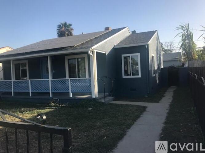 A house with a blue exterior and a white fence.