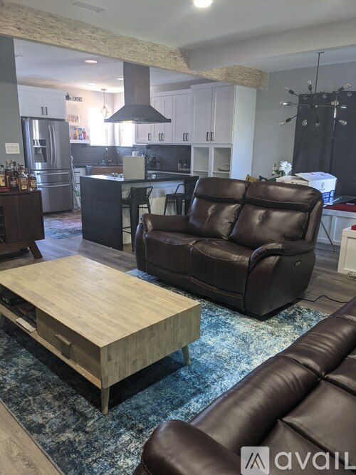 A living room with a brown leather couch and a wooden coffee table.