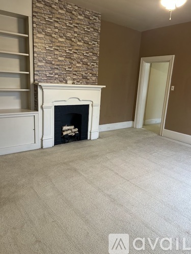 A room with a fireplace and a carpeted floor.