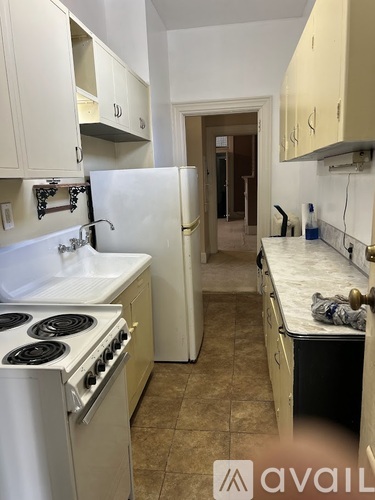 A kitchen with a white stove and a white refrigerator.