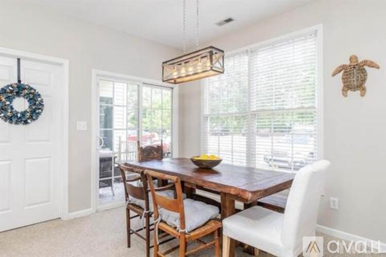 A dining room with a wooden table and chairs.