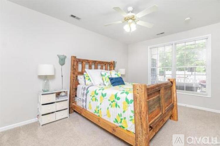 A bedroom with a bed, nightstand, and a ceiling fan.