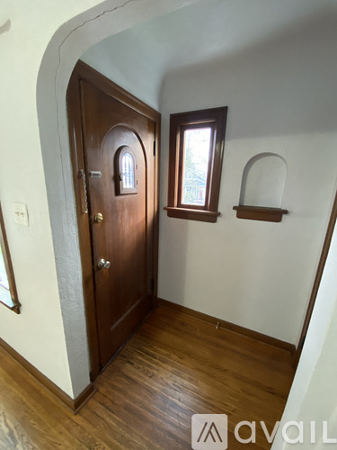 A wooden door with a window above it in a room with wooden floors.