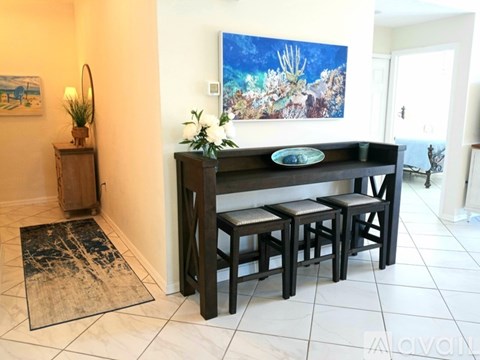 A dining room with a table and chairs.