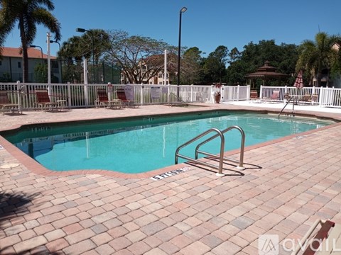A pool with a red brick edge and a metal ladder.