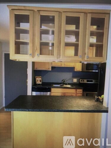 A kitchen with wooden cabinets and a black countertop.