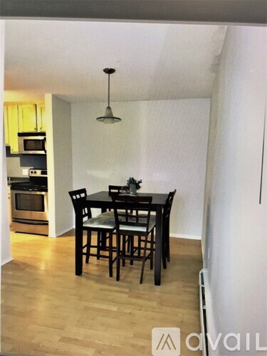 A dining room with a table and chairs.