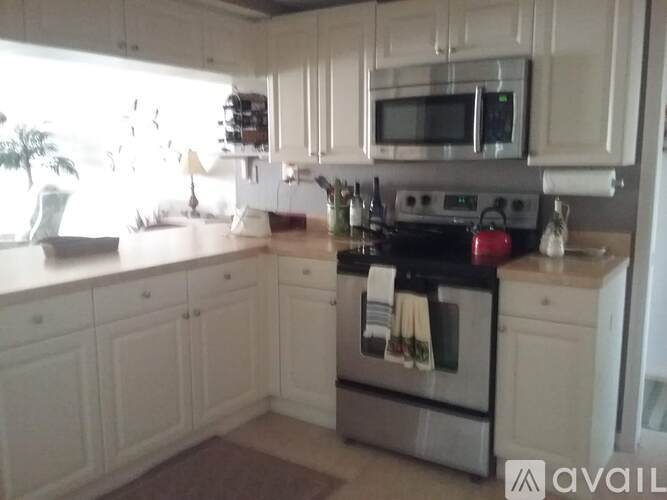 A kitchen with white cabinets and a stainless steel oven.