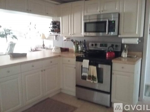 A kitchen with white cabinets and a stainless steel oven.