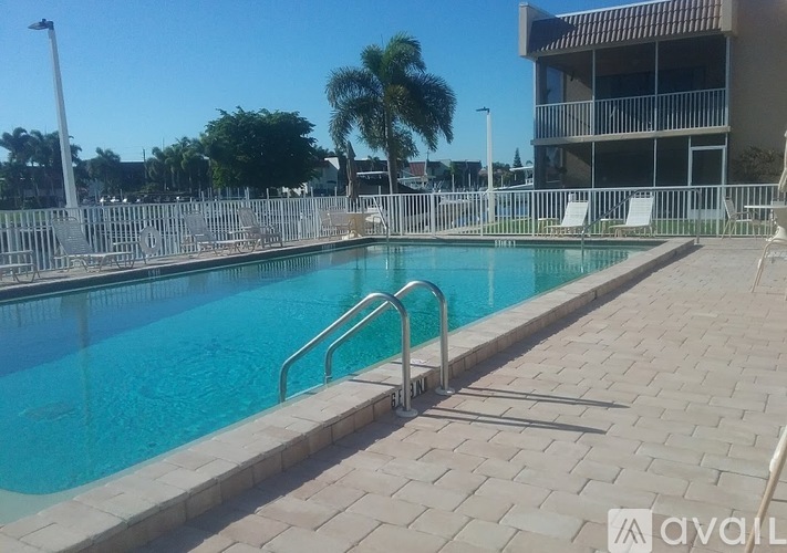 A swimming pool with a metal ladder and a building in the background.