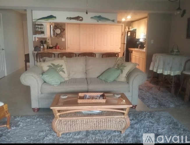 A living room with a couch, coffee table, and a rug.