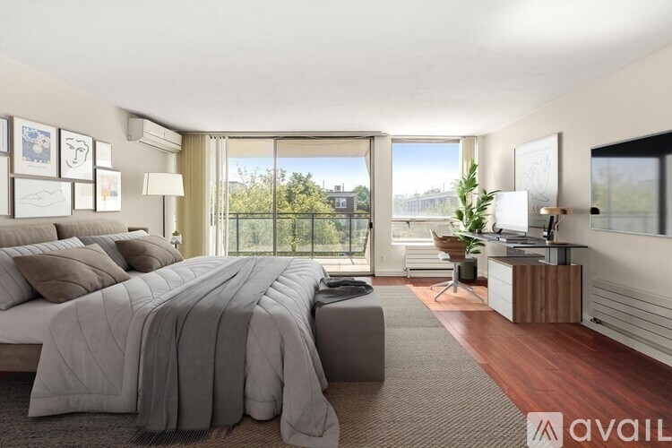 A bedroom with a large bed and a view of the outdoors through the window.