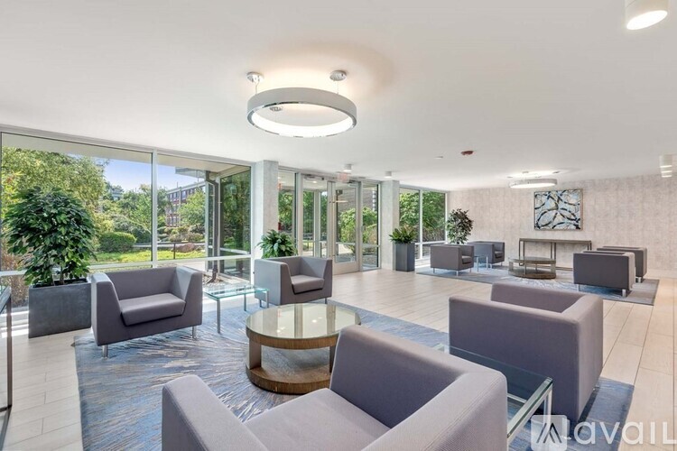 A spacious waiting area with grey couches and a glass table.