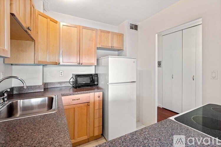 A kitchen with wooden cabinets and a white refrigerator.