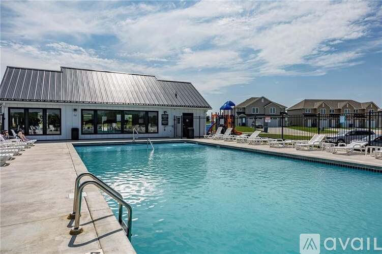 A swimming pool with a metal railing and a building with a metal roof in the background.