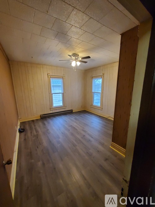 A room with wooden floors and a ceiling fan.