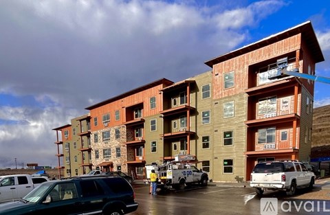 A large multi-story building with a parking lot in front.