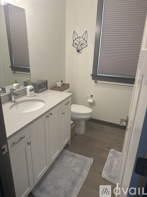 A bathroom with a toilet, sink, and a mirror.