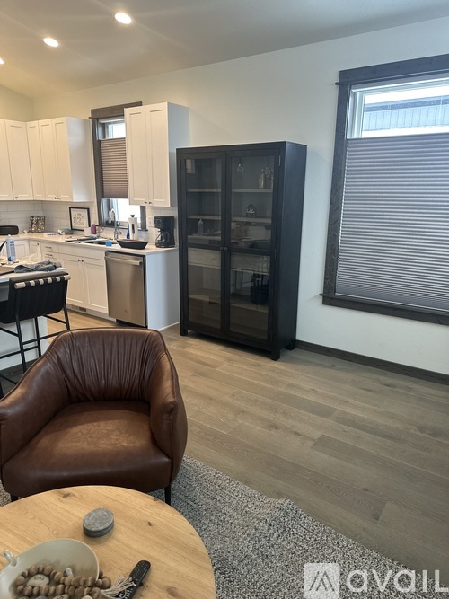 A kitchen with a brown leather chair and a wooden table with a bowl on it.