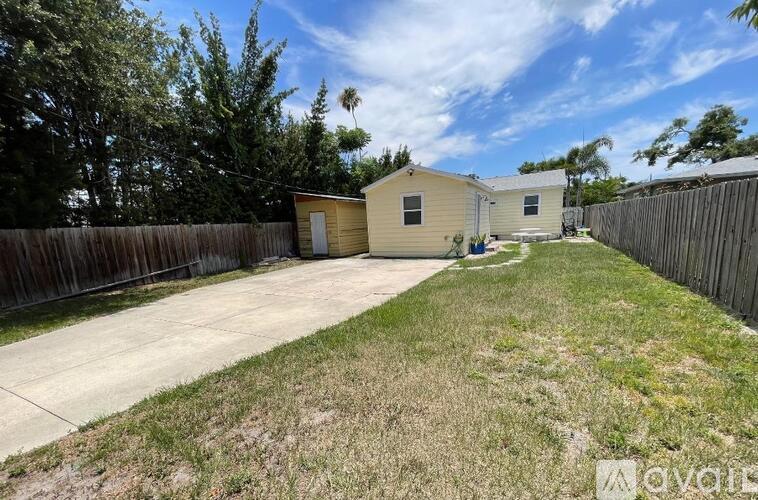 A backyard with a fence and a small building.