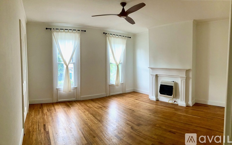 A room with a fireplace and a fan.