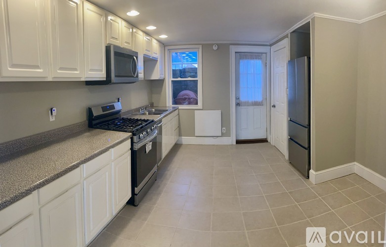 A kitchen with white cabinets and a black stove top oven.