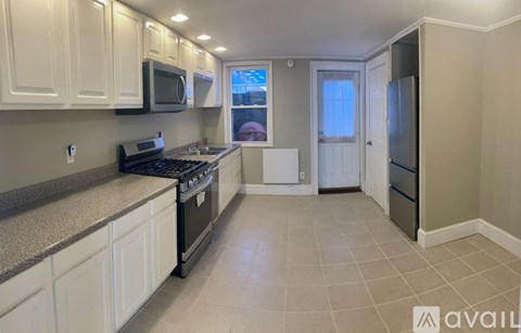 A kitchen with white cabinets and a black stove top oven.