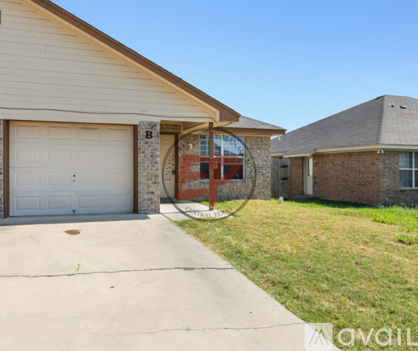 A house with a garage and a driveway in front of it.