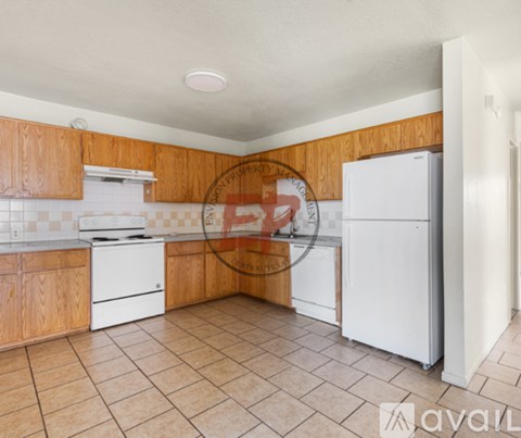 A kitchen with white appliances and wooden cabinets.