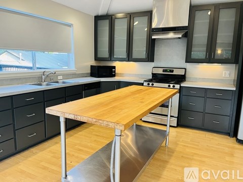 A kitchen with a wooden table and stainless steel appliances.