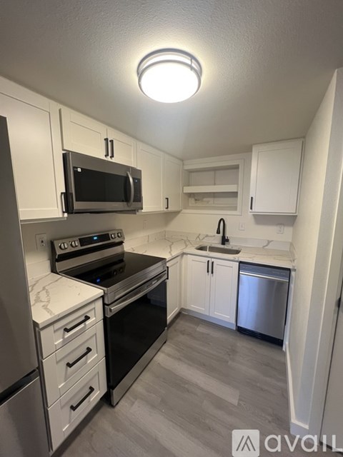 A kitchen with white cabinets and stainless steel appliances.