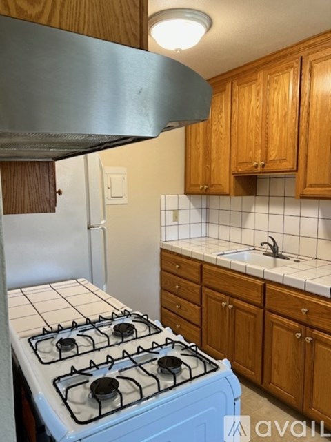A blue gas stove in a kitchen with wooden cabinets.