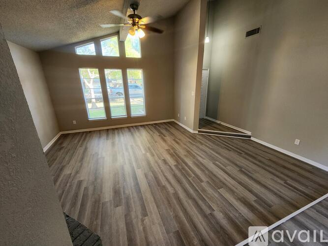 A room with wooden flooring and a ceiling fan.