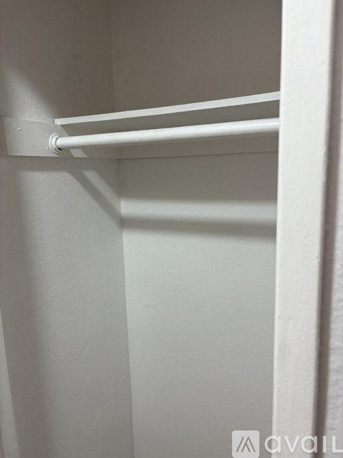 A white shelf is mounted on a white wall.