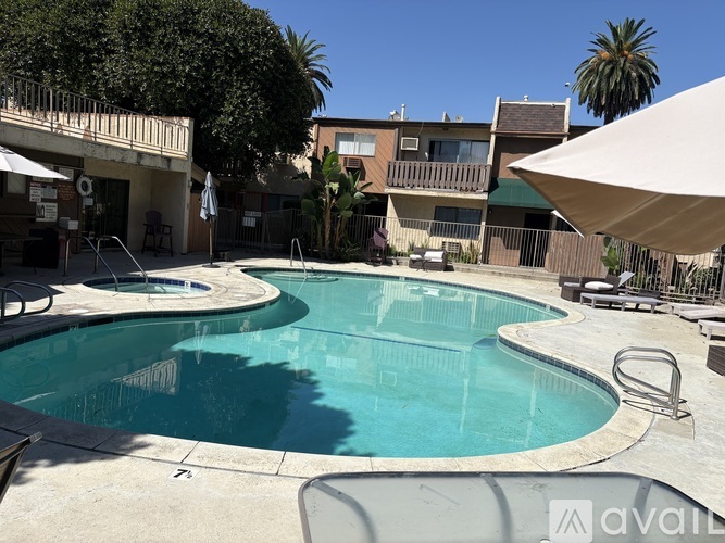 A pool surrounded by a patio and chairs.