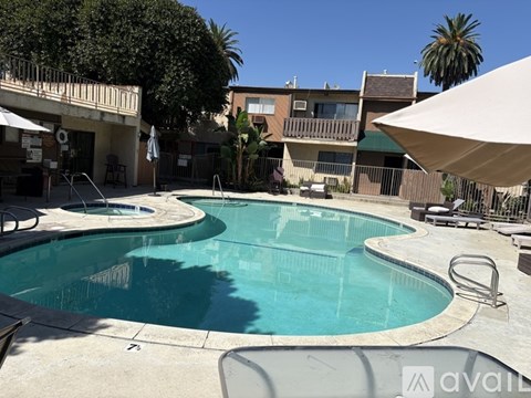 A pool surrounded by a patio and chairs.