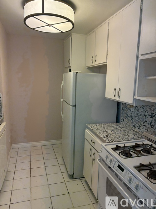 A kitchen with a white refrigerator and a white stove top oven.
