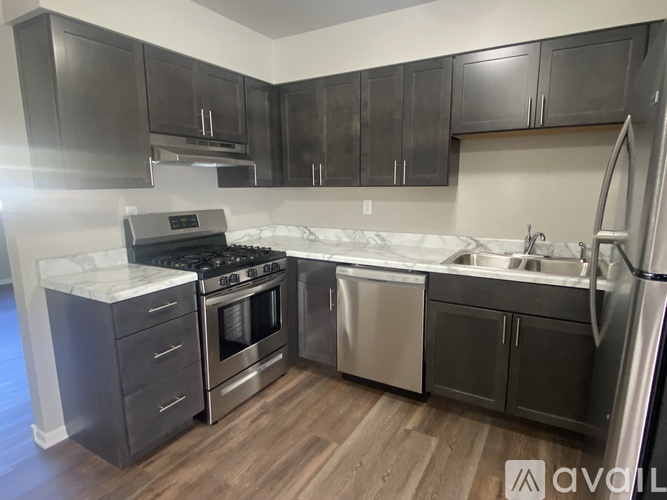 A kitchen with dark wood cabinets and stainless steel appliances.
